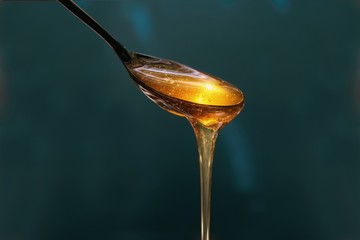 Delicious honey pours out of the spoon close up - Powered by Adobe