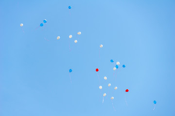 white, blue and red balloons in the sky