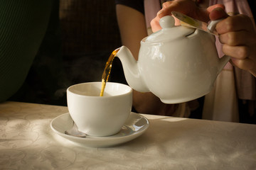 cup of tea with teapot and cup on wooden table