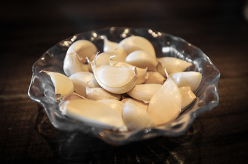 Garlic Cloves in glass plate on the wood table view
