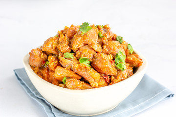 Chinese Style Stir-Fried Chicken in a White Bowl on White Background.