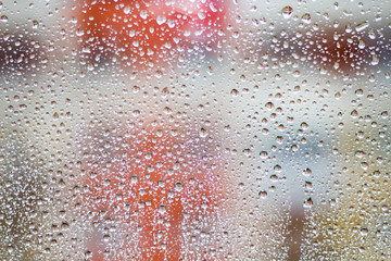 raindrops on glass on blurred colorful background.