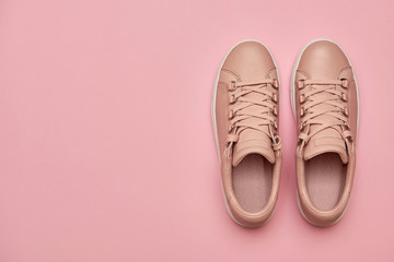 Stylish pink female shoes on pastel background, copy space. New sneakers on pink background. Beauty and fashion concept. Flat lay, top view. Overhead shot