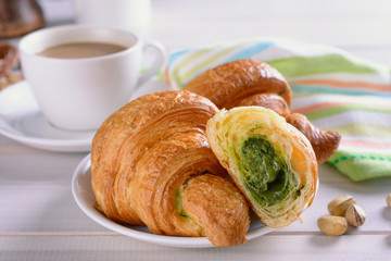Croissants filled with pistachio cream praline as delicious breakfast with coffee