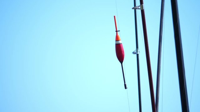 Fishing tackle, fishing rods and float, against the blue background of the sky.