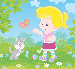 Smiling little girl playing with a small grey kitten among flowers on green grass of a lawn on a sunny summer day, vector illustration in a cartoon style