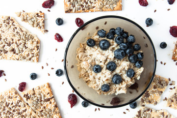 White background with grain cookies fresh blueberries, dried cranberries. Oatmeal with blueberries. Useful snack, proper nutrition. Healthy breakfast. Food for vegans.