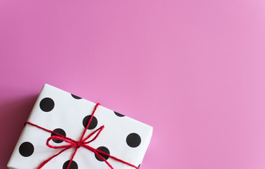 Gift wrapping. Packed gifts, Boxes white paper with black polka dots, paper for gifts, on a pink background. Gifts for Valentine's Day, Birthday, Mother's Day. Preparing for gift wrapping. Parcel