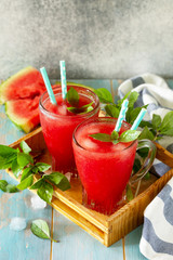 Cold Watermelon Smoothie. Summer Watermelon drink in glasses and slices of watermelon on rustic wooden table. Free space for your text.