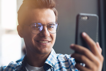 Expect the best & you’ll get it. Close up of a young man using smartphone during coffee break at cafe
