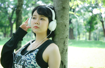 Beautiful sport woman smile portrait and listening music in public park.