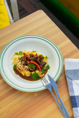 Traditional russian beef stroganoff with gravy, mashed potatoes and caramelized onion served on a wooden table is a perfect comfort food