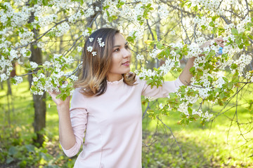 girl with flowers. gorgeous model in the spring garden. the girl near the tree in the spring.