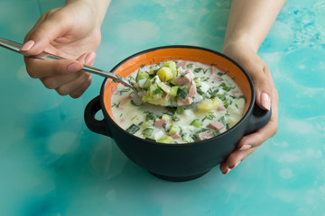 Cold soup okroshka with sausage, eggs, potatoes with sour cream and greens