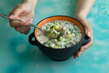 Cold soup okroshka with sausage, eggs, potatoes with sour cream and greens