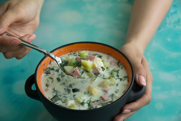 Cold soup okroshka with sausage, eggs, potatoes with sour cream and greens