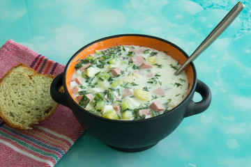 Cold soup okroshka with sausage, eggs, potatoes with sour cream and greens