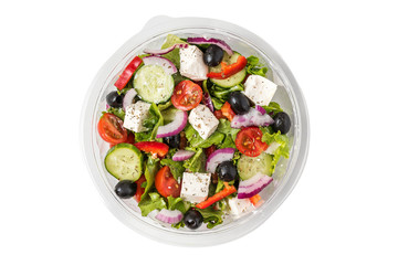 Fresh greek salad in a plastic package to take away for lunch isolated on white background
