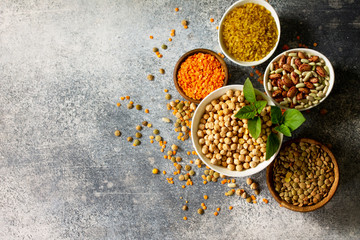 Healthy food, dieting, nutrition concept, vegan protein source. Raw of legumes (chickpeas, red lentils, canadian lentils, beans, bulgur, chickpea). Top view flat lay. Free space for your text.