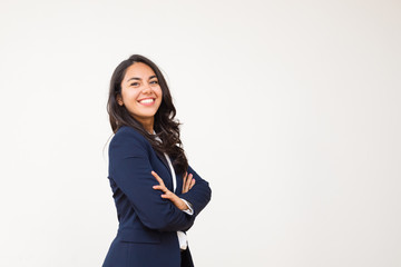 Young businesswoman smiling at camera. Portrait of beautiful happy young woman standing with crossed arms and looking at camera isolated on grey background. Emotion concept