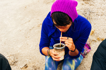 Portrait of Young woman drinking traditional Argentinian yerba mate tea