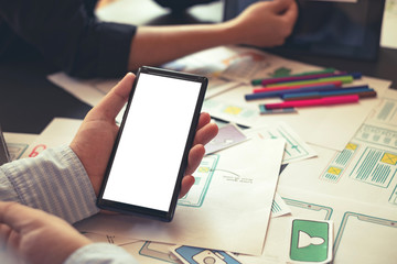 Mock up. Two designer creativity drawing a website outline and website ux app development on mobile phone.