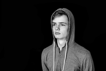 Portrait of a sad teenager on a black dark background