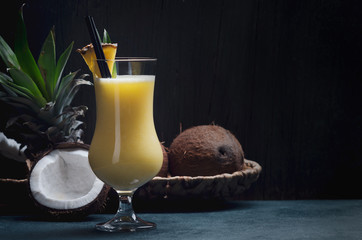 Tropical caribbean cocktail Pina Colada in a glasses on wooden  table with coconut and pineapple.