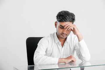 young indian  stressed  employee working at office.