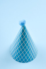 Blue birthday cap on a blue background. Copy space.