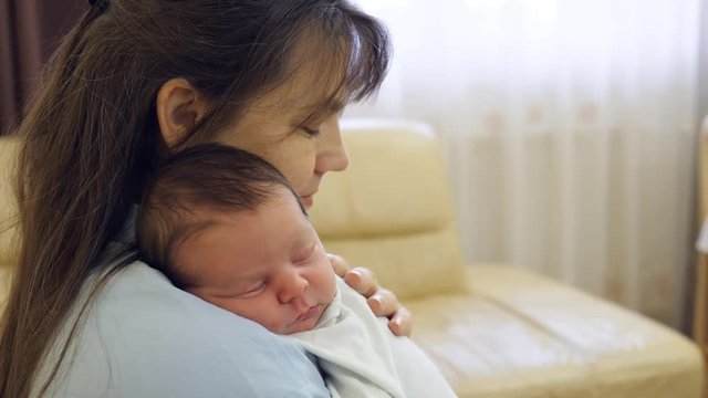 Portrait of cute newborn baby child and happy mother, kid sleep, mother caress