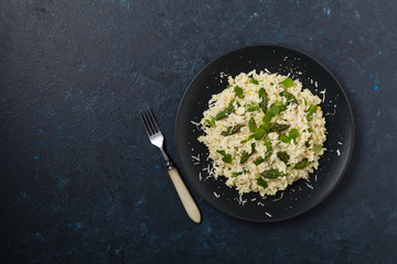Classic Italian risotto with asparagus. Top view. Darkblue background.