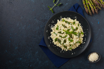 Classic Italian risotto with asparagus. Top view. Darkblue background.