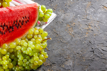 Watermelon and grapes on a stone background. Autumn harvest.