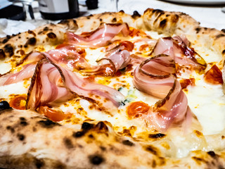 Italian pizza cooked with a wood-fired oven, with mozzarella bacon and tomato