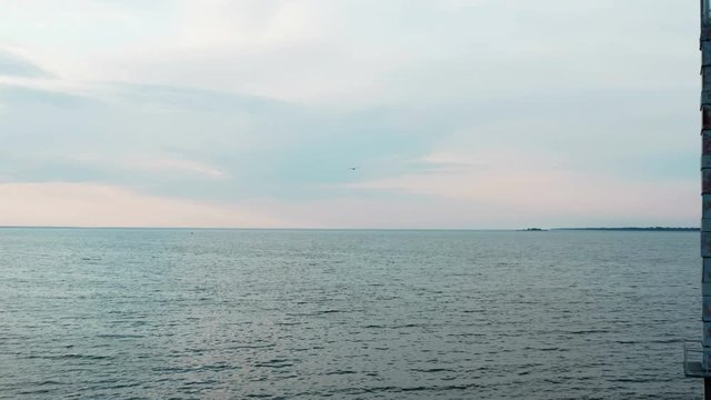 Antique Lighthouse in Soviet constructivism style. Located in the sea at the beautiful sunset landscape . Cinematic footage of flying away with a professional drone equipped with cinema camera. 
