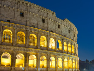 Naklejka premium wall of Colosseum in night illuminating in Rome in Italy