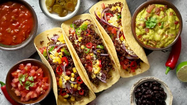 Tasty Mexican meat tacos served with various vegetables and salsa
