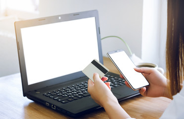 Closeup young asian woman working with laptop and using credit card to payment and shopping on line