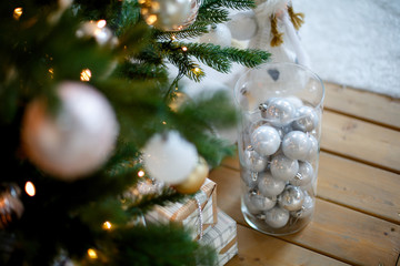 White Christmas decorations in a vase on wooden floor