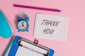 Writing note showing Thank You. Business concept for a polite expression used when acknowledging a gift or service Alarm clock clipboard paper sheets mouse markers colored background