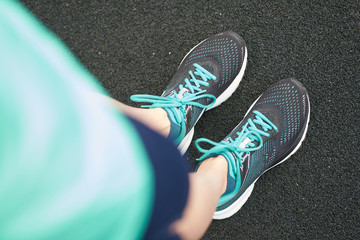 Woman's feet in running sneakers, view from above.