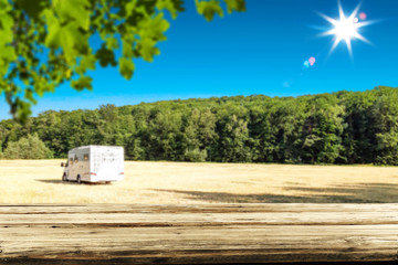 Wooden table top background with mountains in distance. Sunshine in the mountains. Free space for an advertising product.