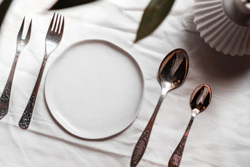 Authentic festive table setting mock up top view. Wedding holiday table setting mockup background for wallpaper, design, lettering, cards, blogs. Tableware with green branch.
