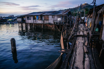 Poor district slums with wooden houses near water at dusk, Coron city, Palawan, Philippines
