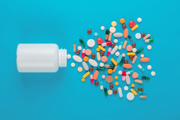Assorted pharmaceutical medicine pills, tablets and capsules and bottle on blue background. Copy space for text © Oleksandr Kozak
