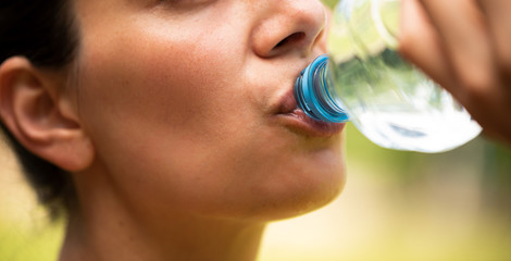Frau trinkt Wasser aus Plastikflasche - obrazy, fototapety, plakaty