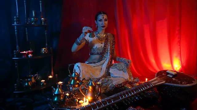 Beautiful young indian woman in traditional Sari clothing with Oriental Jewelry with a bell