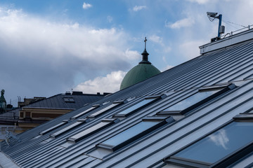Fototapeta na wymiar Roof windows and skylights and blue sky