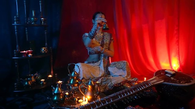 Beautiful young indian woman in traditional Sari clothing with Oriental Jewelry with a bell